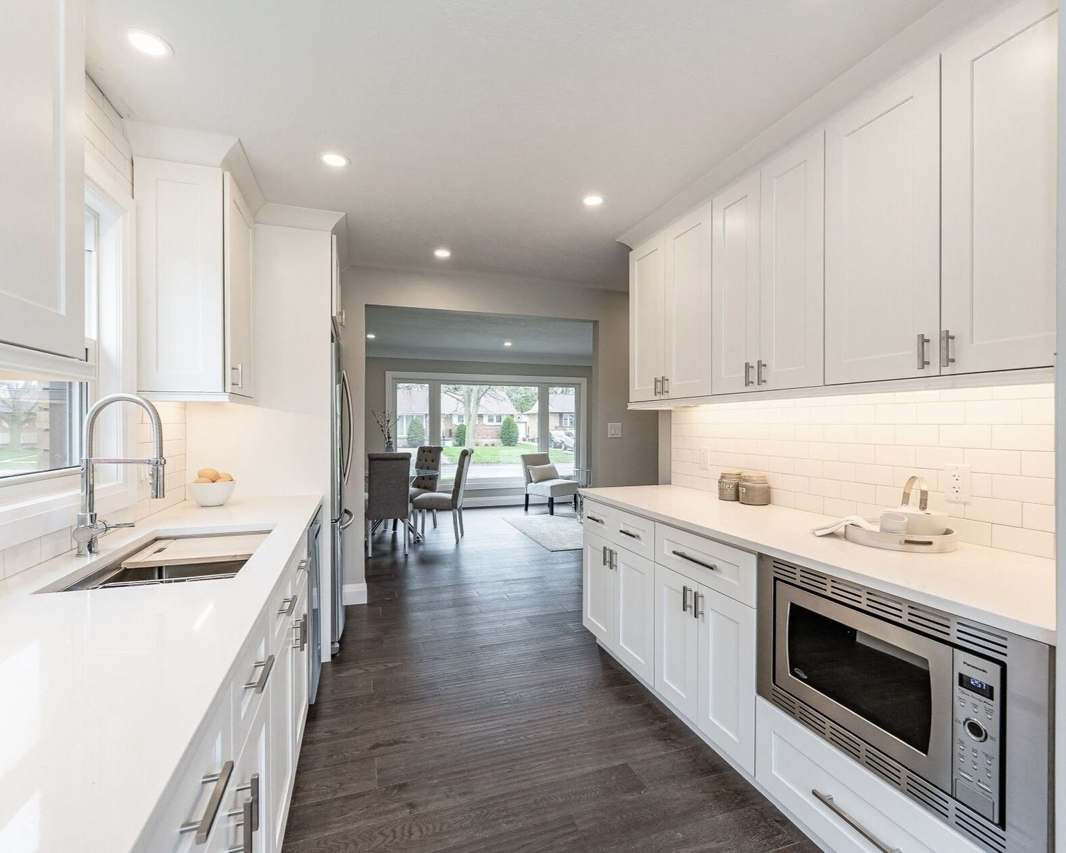 A bright finished kitchen with ceiling and under-cabinet lighting from Deno’s portfolio.